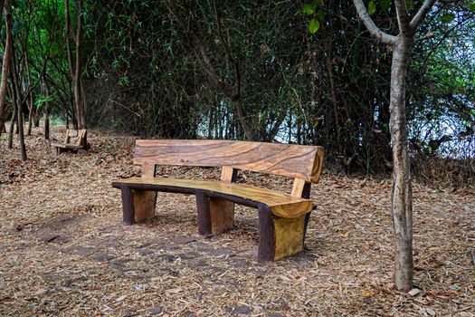 Abstarct , uniquely designed , isolated image of  curved wooden bench made of natural wood in a recreation park.