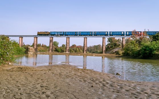 Indian Railways narrow gauge train crossing Marhu river bridge with river near Nagpur, Maharashtra, India.