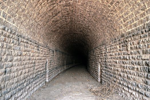 Inside photograph of an old stone arch tunnel erstwhile used to carry a narrow gauge railway line near Pune.