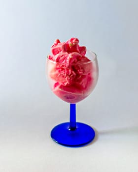 Isolated image of delicious pink strawberry ice-cream in a tranparent wine glass on a clear white background.