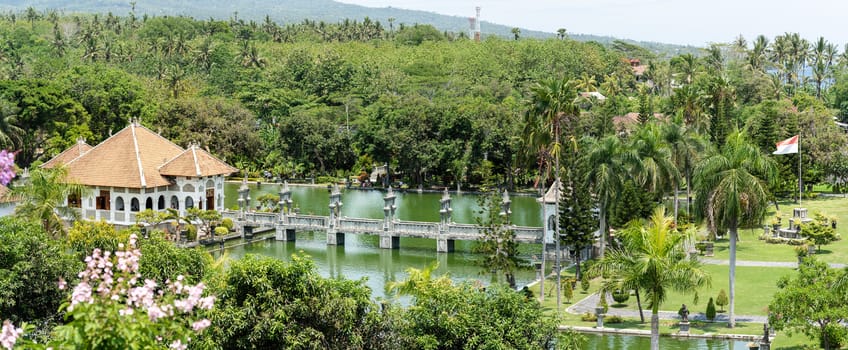 Taman Ujung Water Palace is a popular landscaped garden with a pond and water pavilions, ornate with statues of Balinese folklore and typical trees, originally a royal palace near Ubud, Bali Island, Indonesia