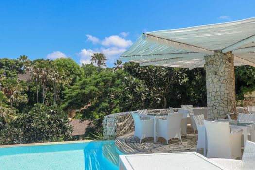 Swimming pool area at ultra modern hotel, Bali, Indonesia. A place to sit and relax under an umbrella.
