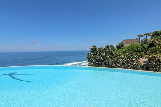Luxury infinity pool with sea views and palm trees. Bali, Indonesia.