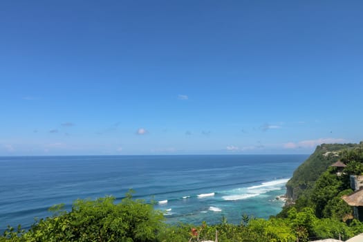 Beautiful blue sunset on the ocean with big waves and cliffs and cliffs. Bali island with its tropical and exotic nature. Sunrise over the sea and ocean. Phantom blue in sunset.