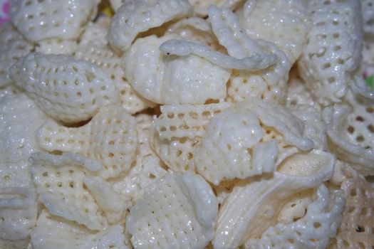 Closeup view of freshly fried chips as fast food for tea break. Potato chips with spices sprinkled on it. Fast food background for advertisements.