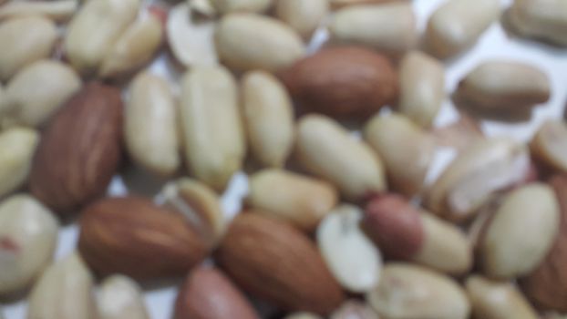 Closeup view of mixed dried and roasted  peanuts and almonds. A fruit for background text