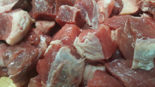 Close up view of fresh finely chopped meat cubes. Red meat small steaks with whitish meat fat.