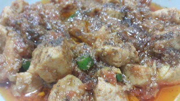 A close up view of stewed chicken meat cubes with spices on it, a traditional home made delicious chicken meat dish