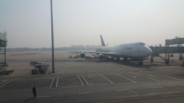 Beijing Airport, china- April 2019: Passenger plane standing in airport on the concrete paved runway terminal for loading, boarding and maintenance before take off for predestined flights.