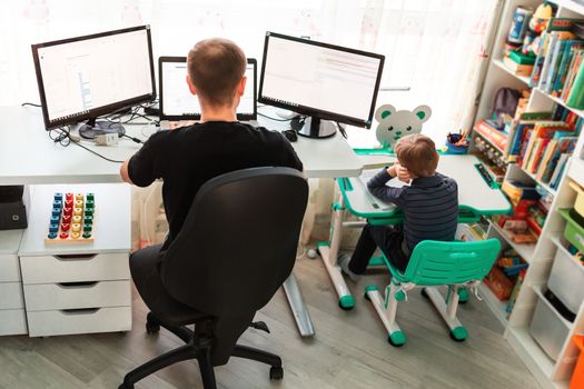 Father with kid trying to work from home during quarantine. Stay at home, work from home concept during coronavirus pandemic