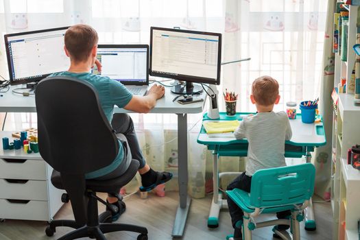 Father with kid trying to work from home during quarantine. Stay at home, work from home concept during coronavirus pandemic