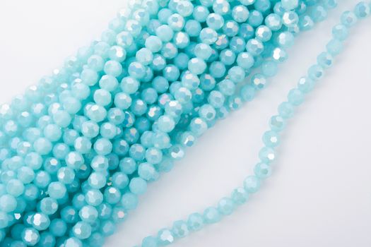 Beautiful Light Blue Glass Sparkle Crystal Isoalted Beads on white background. Use for diy beaded jewelry. Space for text