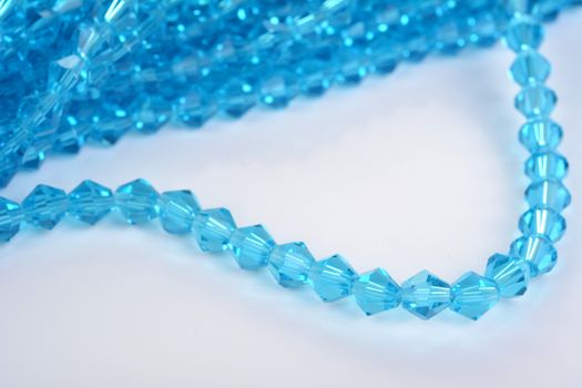 Beautiful Light Blue Glass Sparkle Crystal Isoalted Beads on white background. Use for diy beaded jewelry. Space for text