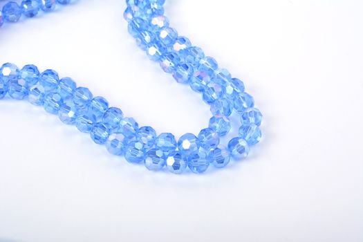 Beautiful Light Blue Glass Sparkle Crystal Isoalted Beads on white background. Use for diy beaded jewelry. Space for text