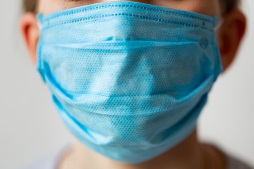 Close up of a face in medical protective mask. Coronavirus protection, wearing masks concept