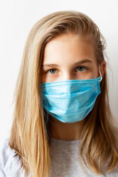 Little teenage girl in medical mask sad and scared. Coronavirus protection, wearing masks concept