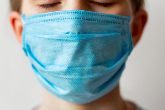 Close up of a face in medical protective mask. Coronavirus protection, wearing masks concept