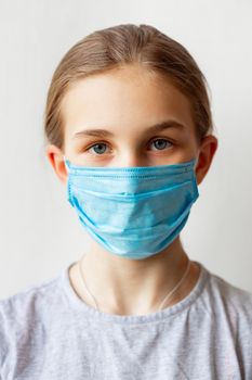 Little teenage girl in medical mask sad and scared. Coronavirus protection, wearing masks concept