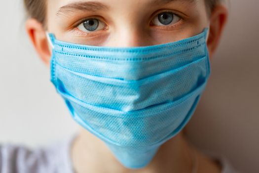 Little teenage girl in medical mask sad and scared. Coronavirus protection, wearing masks concept