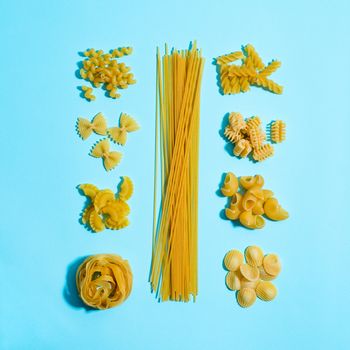 Pasta concent. Differernt types of pasta on blue background. Creative layout pasta guide concept. Food knolling. Pasta art. Top view or flat lay.