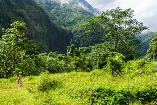 Tahiti Jungle, French Polynesia--March 18, 2018. Woman stands observing nature in the Tahitian jungle.