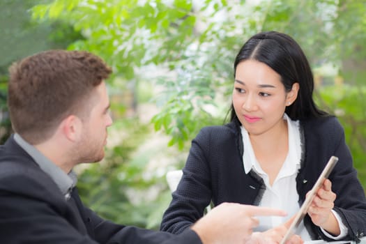 business man and woman people making meeting and looking at tablet for analyzing marketing working at office on desk.