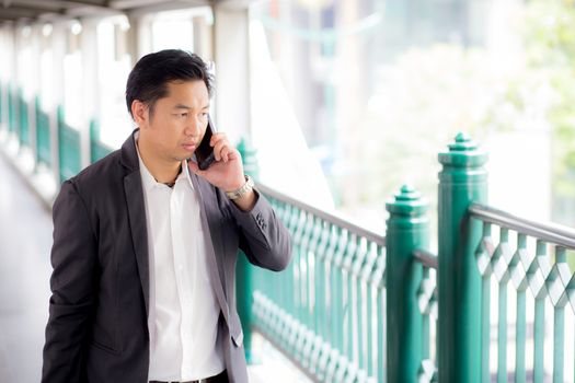 Portrait of a confident business man talking cell phone call outdoor. 