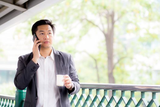 Portrait of a confident business man talking cell phone call outdoor. 