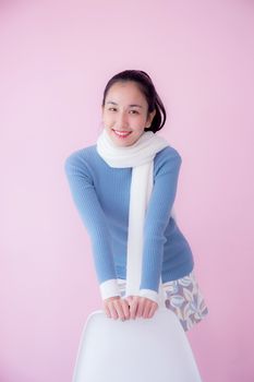 Happy beautiful young woman asian wearing scarf sitting on living room pastel color tone.