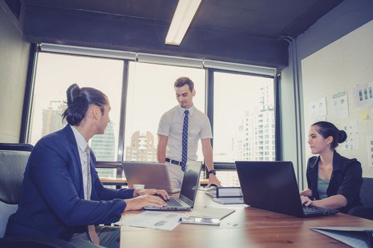 Businesspeople with leader discussing together in conference room during meeting at office.