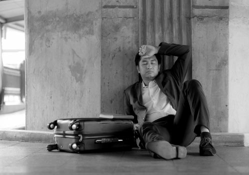 Stressed asian businessman bankrupt with sitting at outdoor.