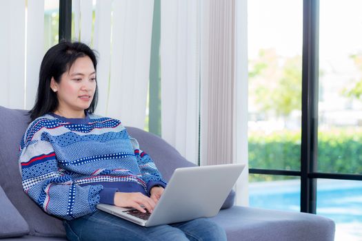 Closeup computer notebook on sofa with asian woman for work in lifestyle of woman concept