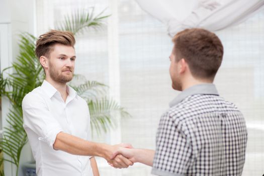 Two business colleagues handshake during meeting.