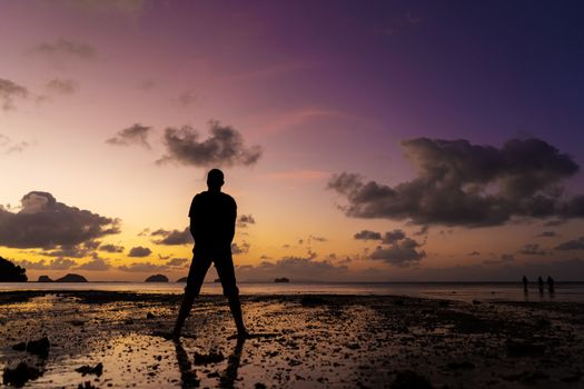 Silhouette of a man on the beach at sunset. Man rejoices meets the sunset.