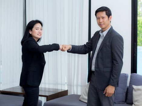 businessmen giving fist bump after business achievement in meeting room - teamwork concept.