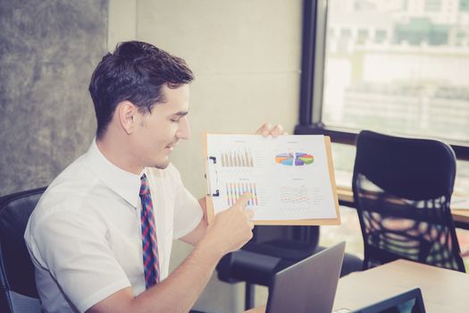 Business people discussing the charts and graphs showing the results of their successful teamwork in meeting room.