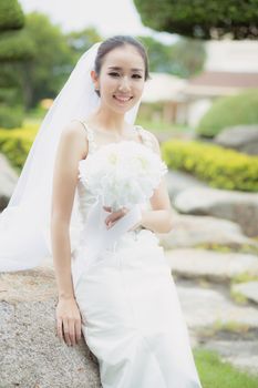 beautiful young woman on wedding day in white dress in the garden. Female portrait in the park - Selective focus.