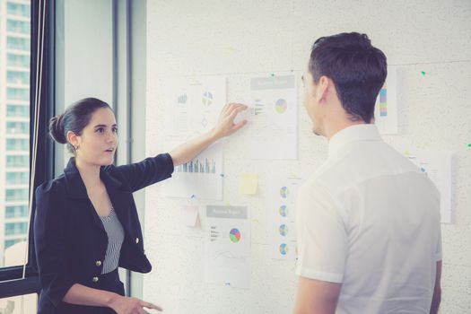 two business people in modern office looking report and analyzing with talking in meeting room.