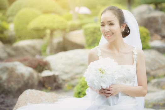 beautiful young woman on wedding day in white dress in the garden. Female portrait in the park - Selective focus.