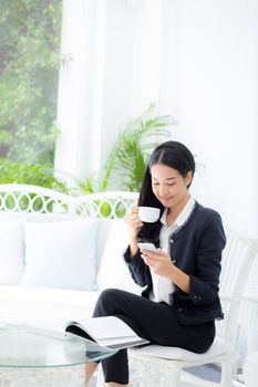 Young businesswoman asian sitting at table in coffee shop and looking phone.