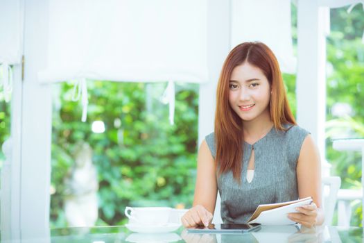 Beautiful businesswoman have enjoyed in the garden with tablet.