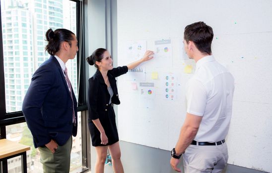 three business people in modern office looking report and analyzing with talking in meeting room.