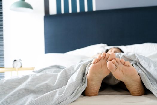 Feet of a sleeping girl in bed in the morning. Spy photo