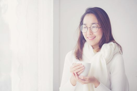 Portrait of bedroom concept: asian woman holding a cup of coffee with on bedroom in breakfast time.