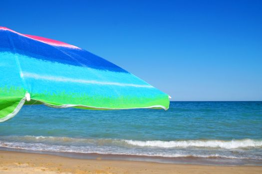 beach umbrella against the sea horizon and clear sky, copy space