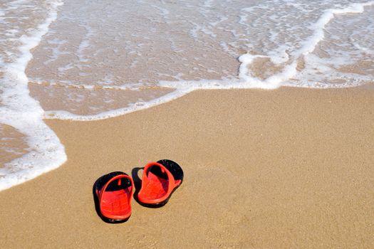 red slates on an empty sandy beach near the sea waves, copy space