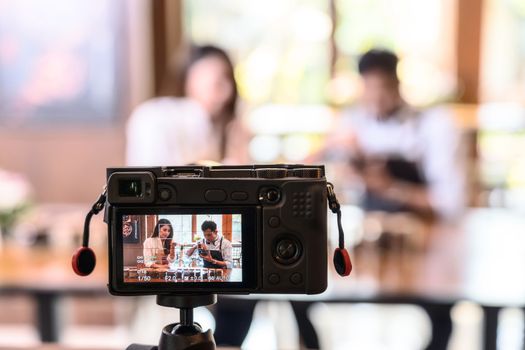 Camera taking Video to two Asian Barista presenting a cup of coffee, smell coffee bean and show to audience in coffee shop,making espresso and americano, Small business owner and influencer concept