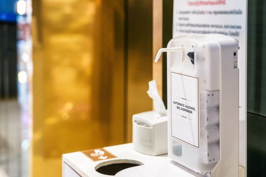 Automatic alcohol gel dispenser on the waste bin in front of elevator in department store after Relief measures Covid19 Outbreak, Coronavirus pandemic, Social distancing and new normal concept