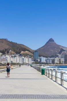 Mountains, hotels and deep blue water with waves at the Sea Point, beach promenade in Cape Town South Africa.