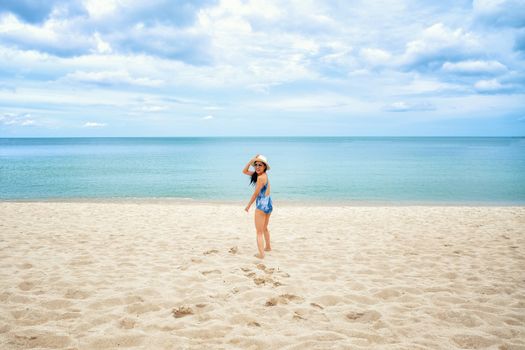 Young happy woman running on the beach